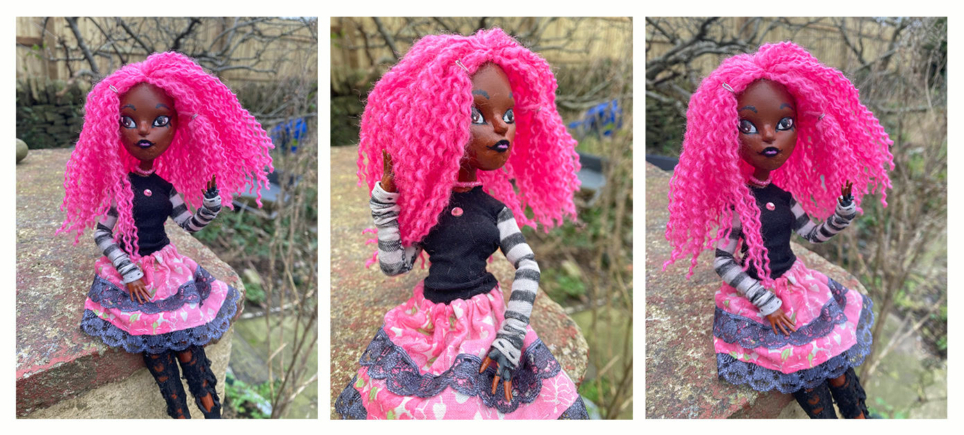 Custom doll with dark skin and pink hair.