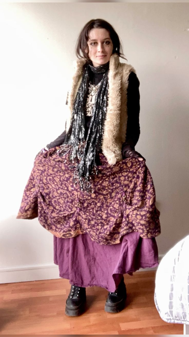 person in fluffy vest and black sparkly scarf.