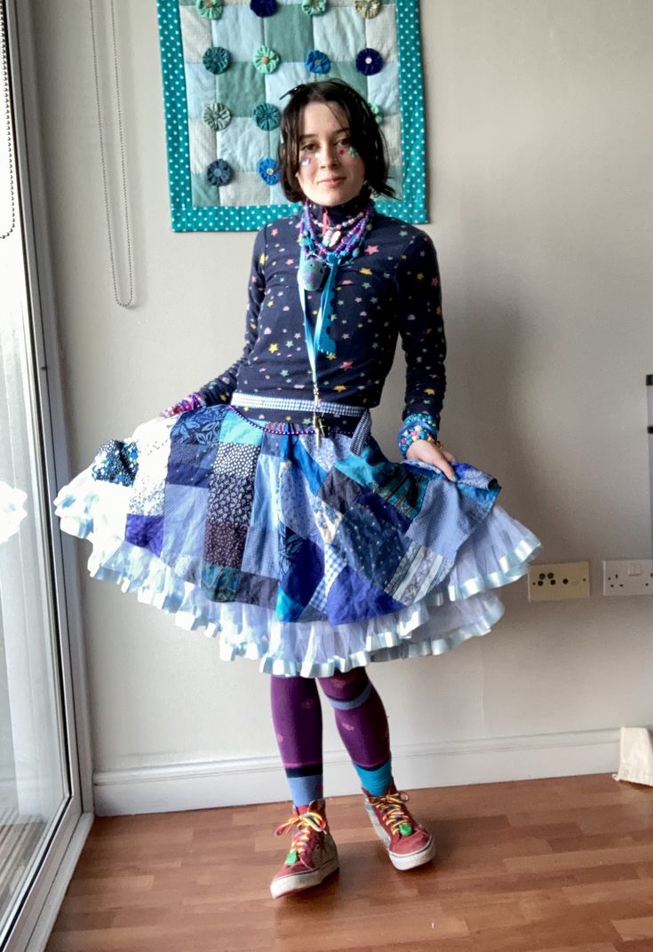 person in blue outfit with patchwork skirt.