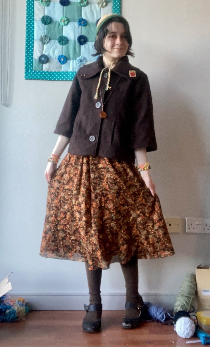 person in brown jacket and autumnal coloured skirt