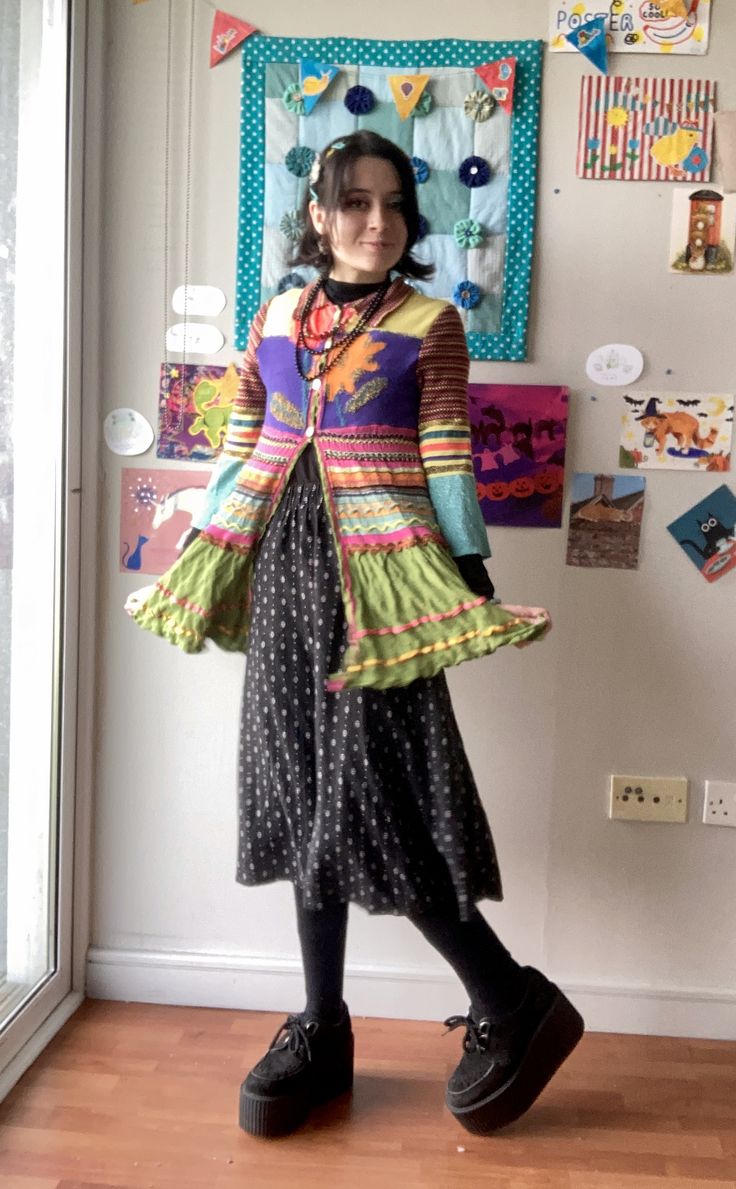 person in colourful cardigan and long black skirt
