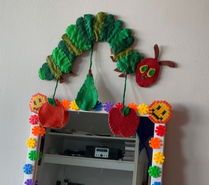 A felt wall hanging of the very hungry caterpillar.