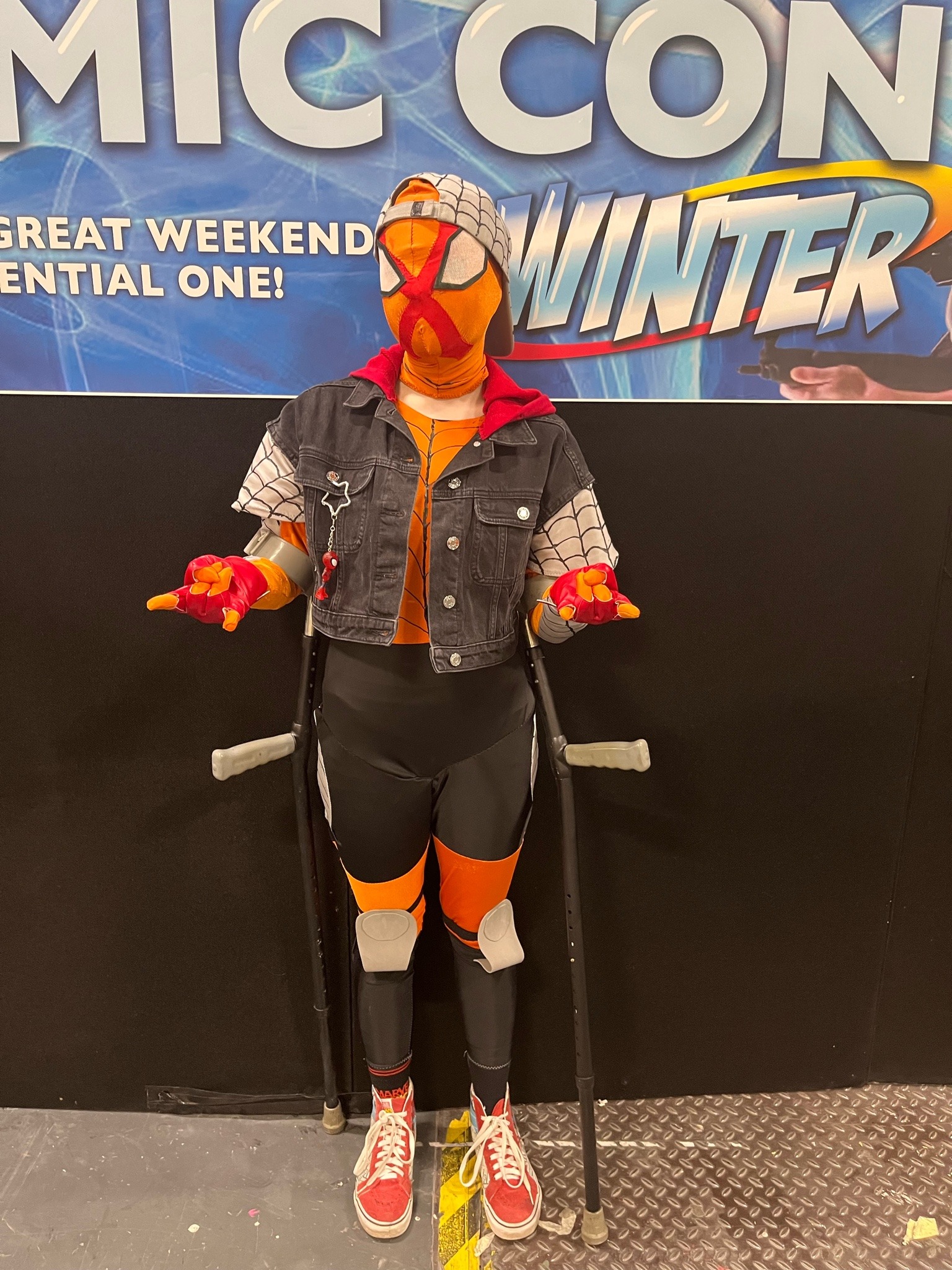 Person in Sun-Spider cosplay making 'thwip' hand gestures.